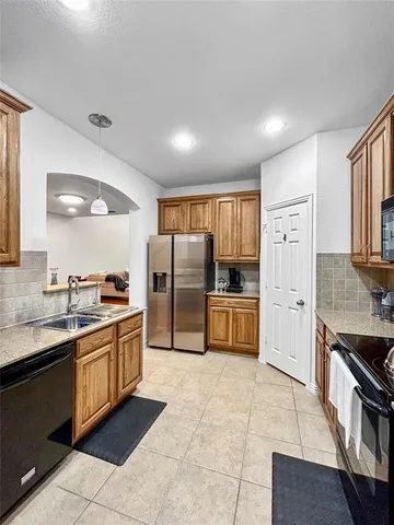 a large kitchen with stainless steel appliances lots of counter top space cabinets and a sink