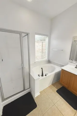 a bathroom with a tub a sink and a window