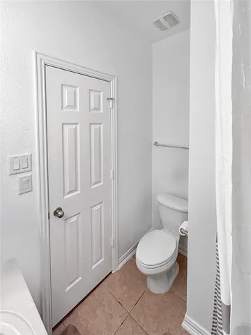 a white toilet sitting next to a shower