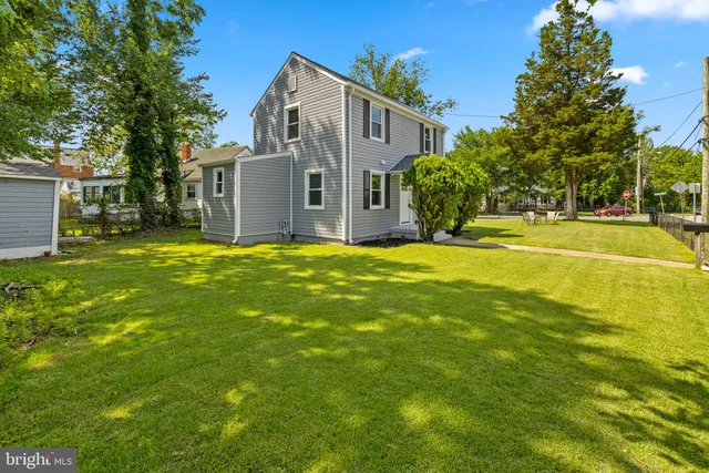 a view of a house with a big yard and large trees