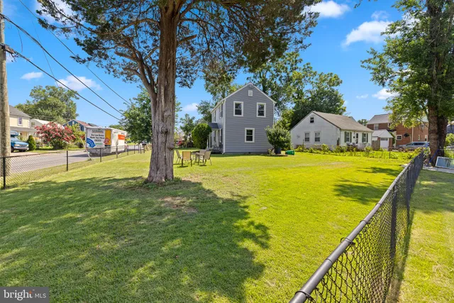 a view of swimming pool with lawn chairs and plants