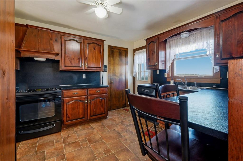 127 East Buffalo Church Road Washington, PA 15301 - Photo 12 of 33 a kitchen with stainless steel appliances granite countertop a stove top oven a sink dishwasher a dining table and chairs with wooden floor