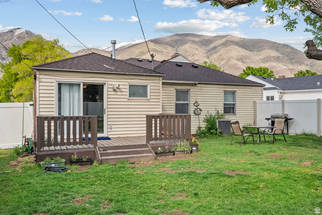 88 East C Street Springville, UT 84663 - Photo 27 of 32 Expansive backyard featuring a manicured lawn, a wood-finish deck with railing, and a sliding glass door