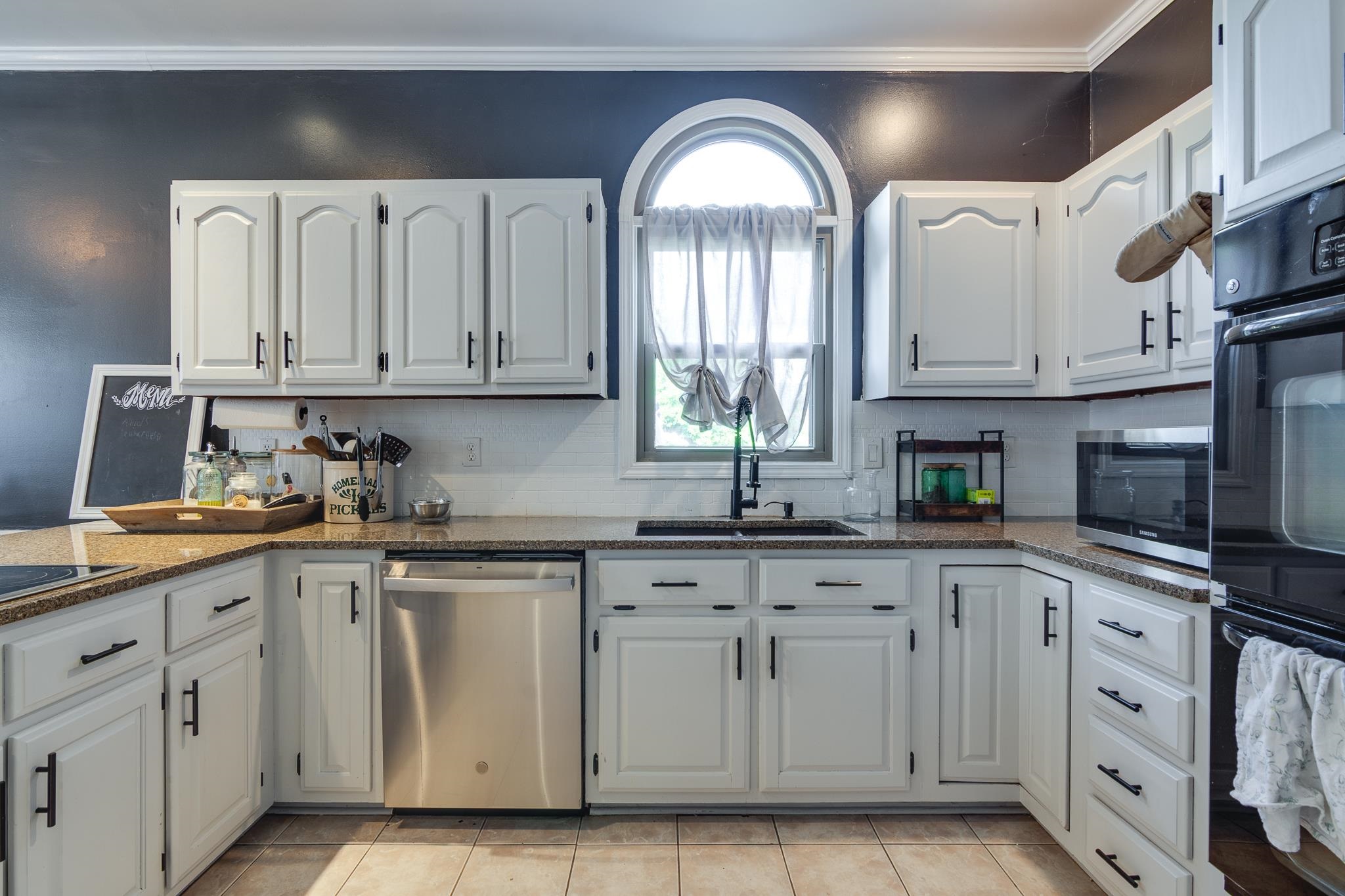 779 Early Earner Cove Collierville, TN 38017 - Photo 10 of 29 Kitchen featuring white cabinetry with dark hardware, speckled countertops, stainless steel dishwasher, and built-in double ovens