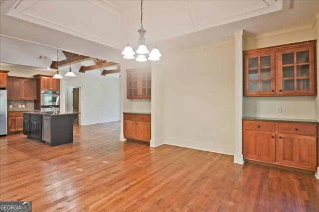 a kitchen with stainless steel appliances granite countertop a stove a sink dishwasher a refrigerator and a oven with wooden floor