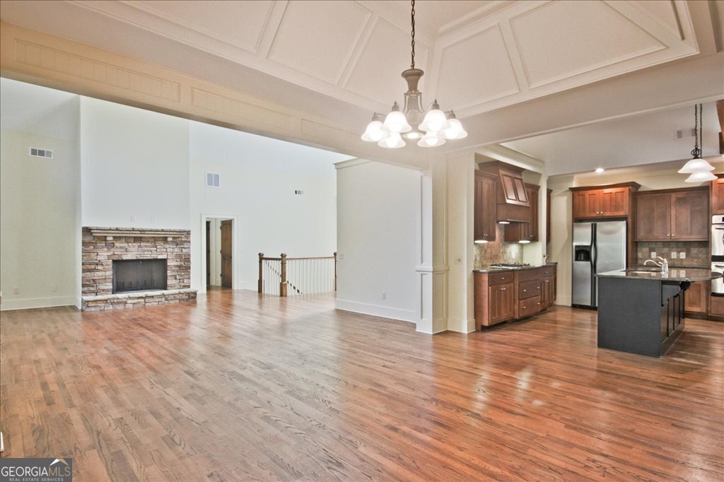 194 Edgewater Trail South Toccoa, GA 30577 - Photo 15 of 70 a view of a livingroom with a fireplace a chandelier and wooden floor