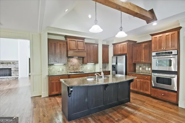 a kitchen with granite countertop a sink and a wooden floor