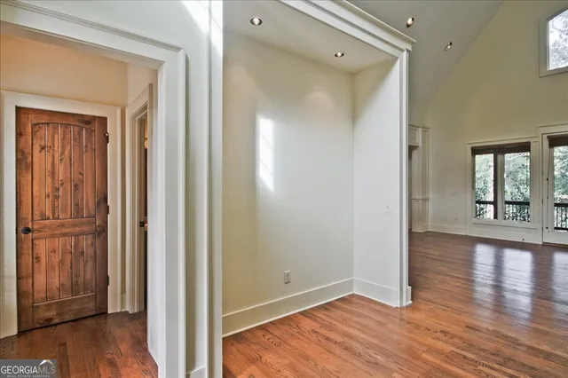 a view of a hallway with wooden floor and stairs