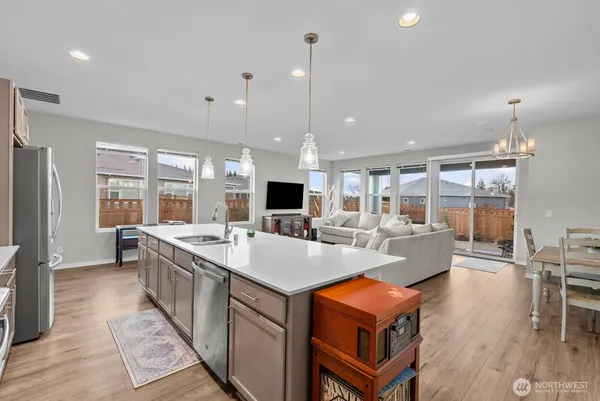 a large kitchen with sink a counter top space and stainless steel appliances