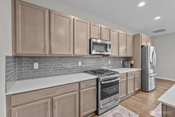a kitchen with appliances a sink and cabinets