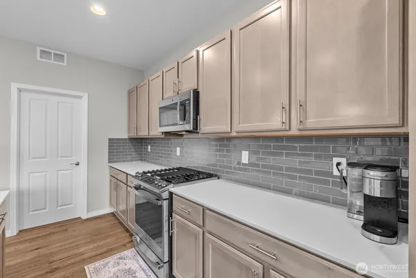 a kitchen with stainless steel appliances white cabinets and a stove top oven
