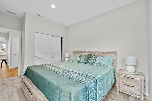 a bedroom with a large bed and a lamp