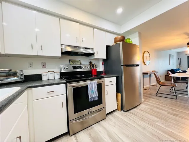 a kitchen with stainless steel appliances white cabinets and white appliances