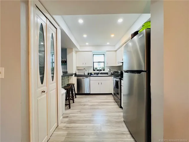 a kitchen with white cabinets and appliances
