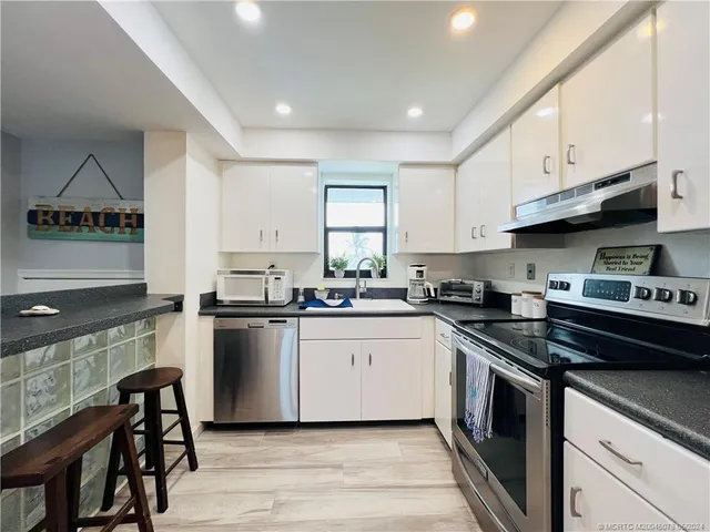 a kitchen with a refrigerator a stove a microwave and cabinets