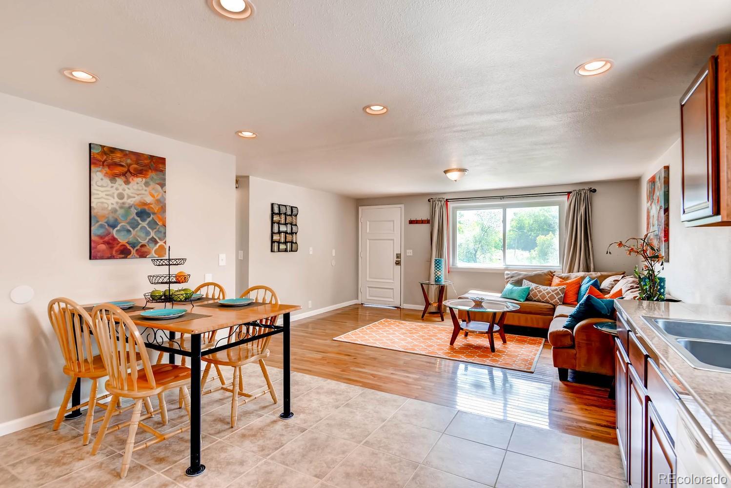 1760 South Java Way Denver, CO 80219 - Photo 11 of 28 a living room with furniture a large window and a dining table