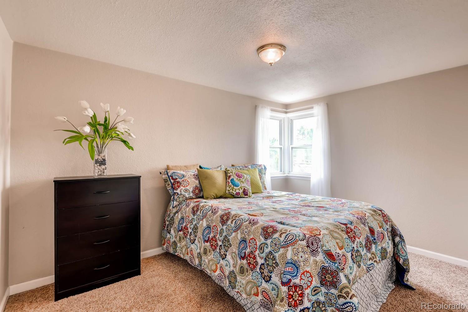 1760 South Java Way Denver, CO 80219 - Photo 12 of 28 a bedroom with a bed and a potted plant