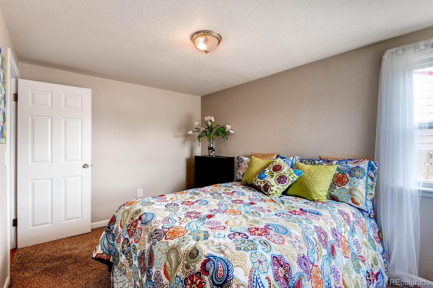 1760 South Java Way Denver, CO 80219 - Photo 14 of 28 a bedroom with a bed and a window