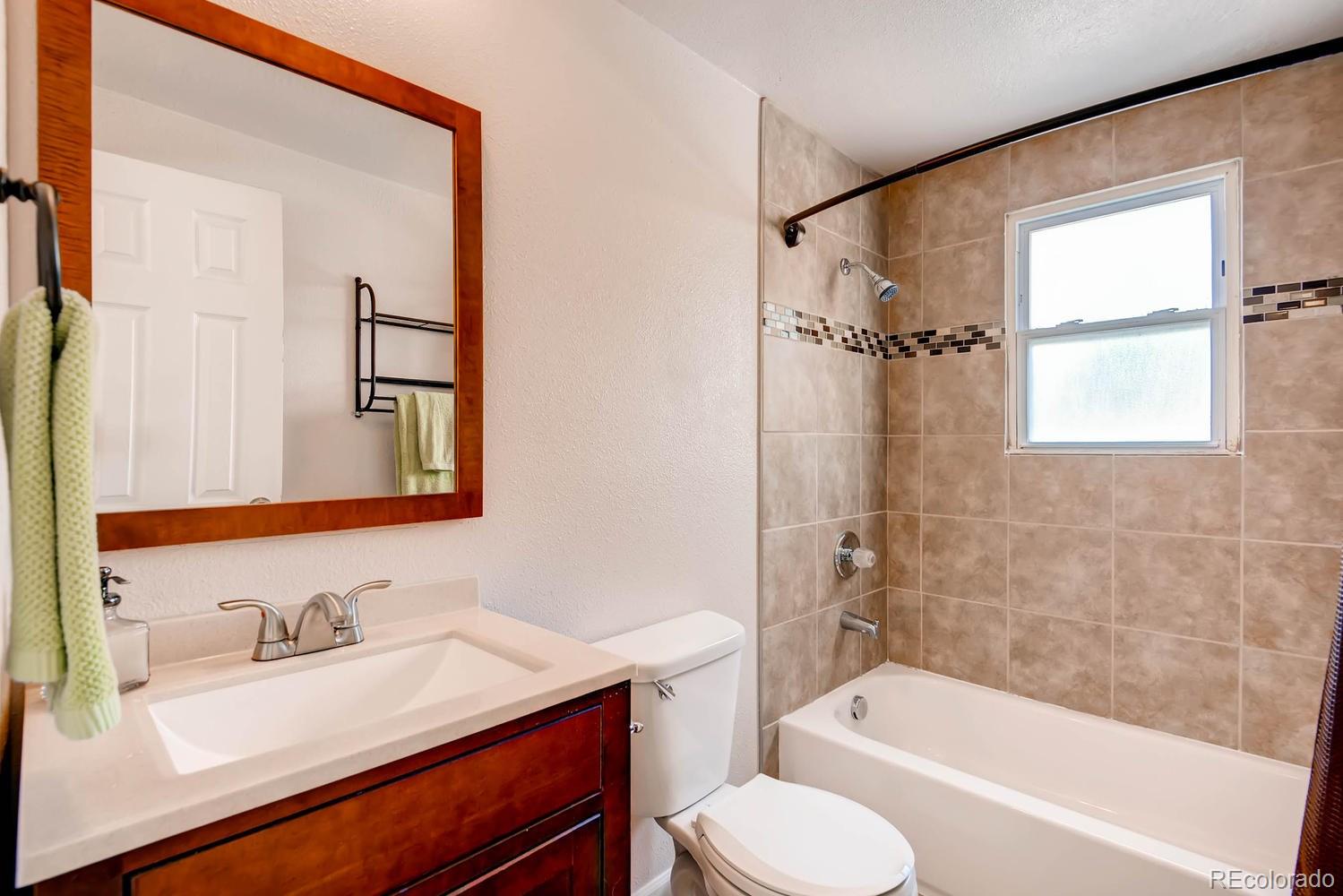 1760 South Java Way Denver, CO 80219 - Photo 15 of 28 a bathroom with a granite countertop sink toilet and shower