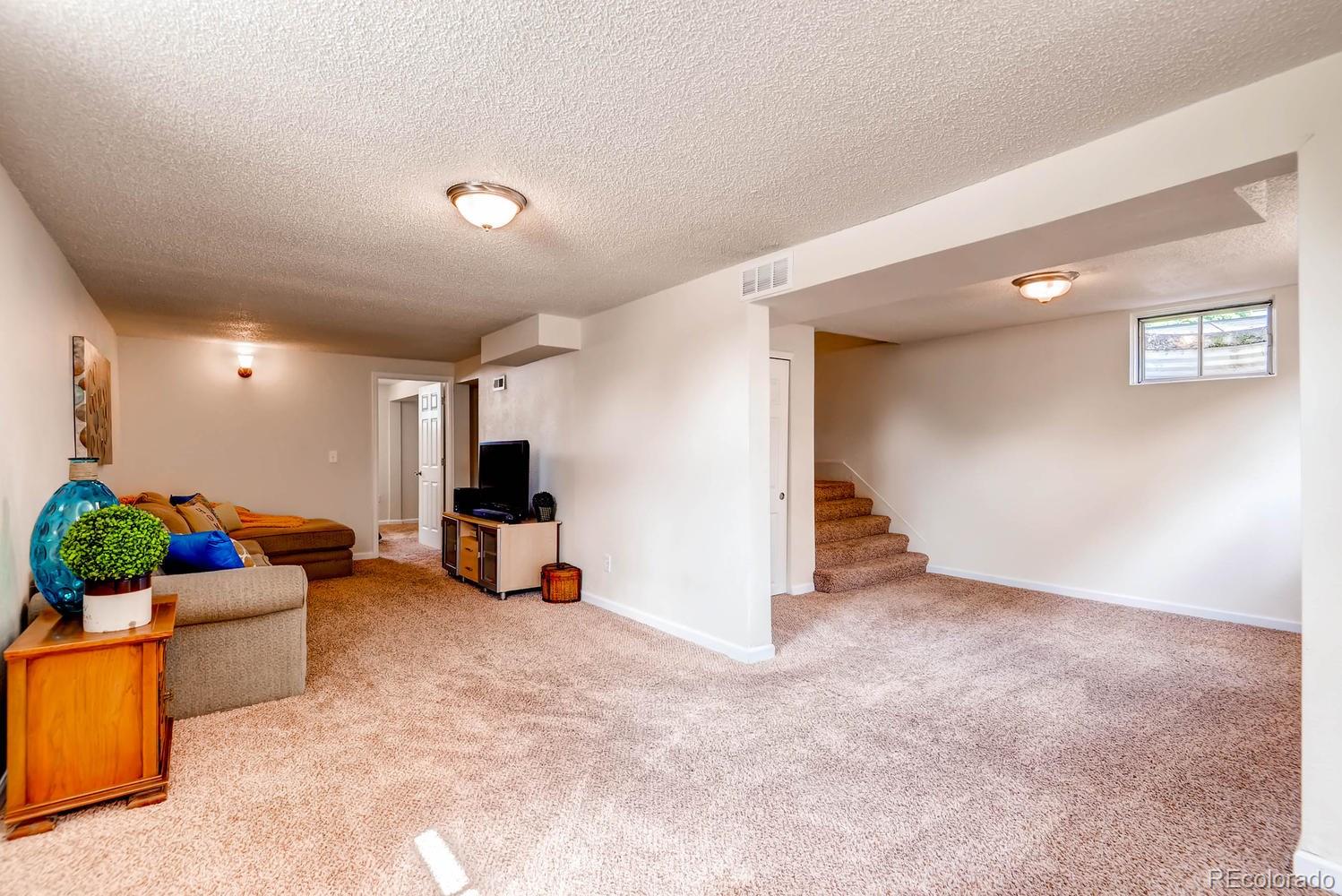 1760 South Java Way Denver, CO 80219 - Photo 19 of 28 a living room with furniture and a flat screen tv
