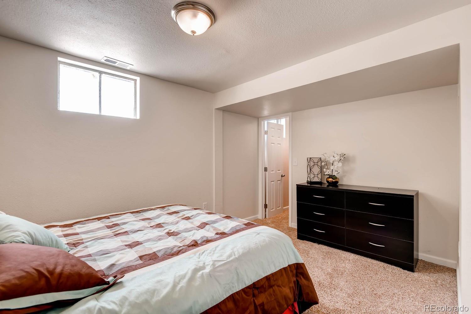 1760 South Java Way Denver, CO 80219 - Photo 22 of 28 a bedroom with a bed and window