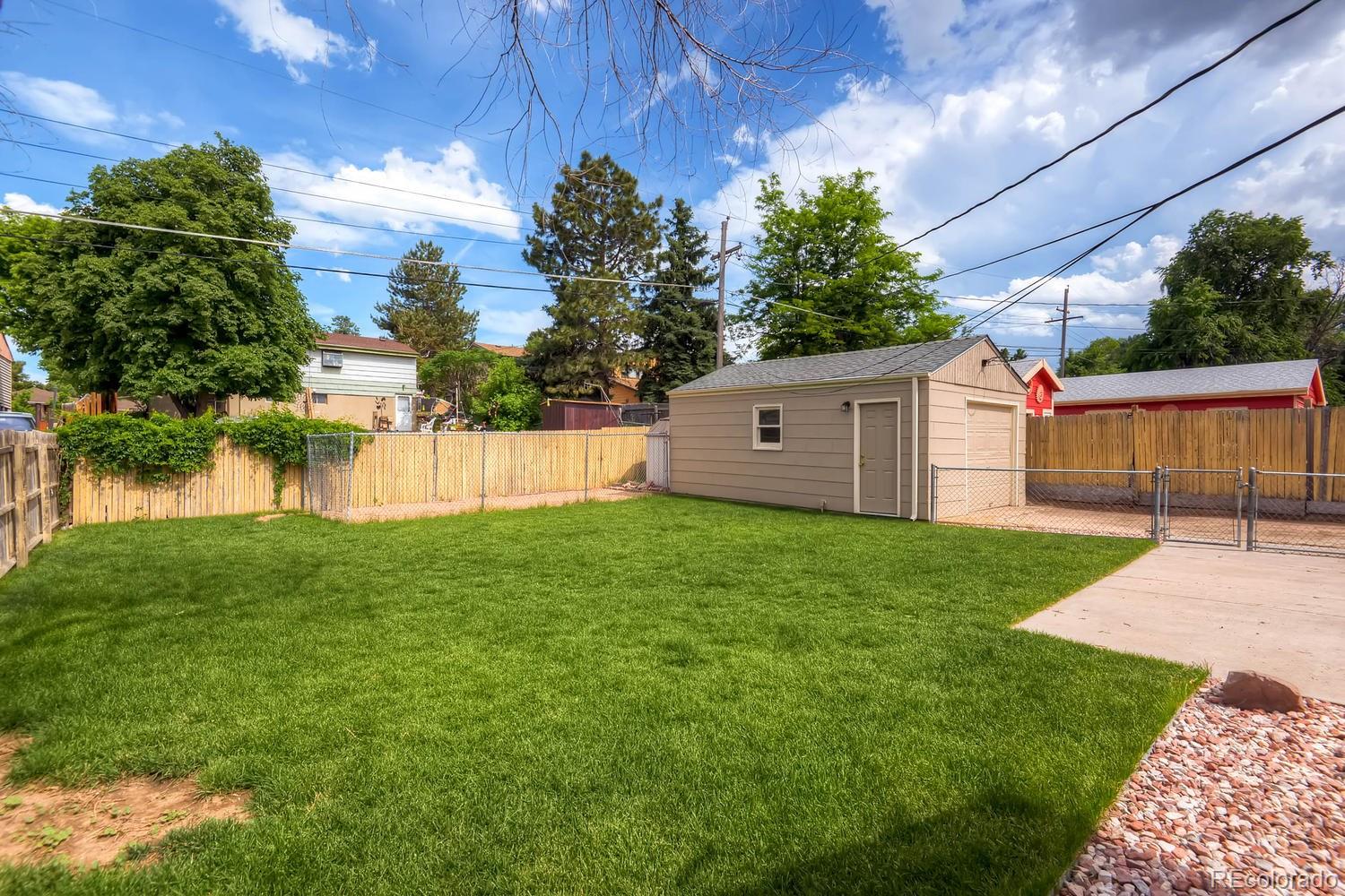 1760 South Java Way Denver, CO 80219 - Photo 25 of 28 a view of a backyard with barn and large trees