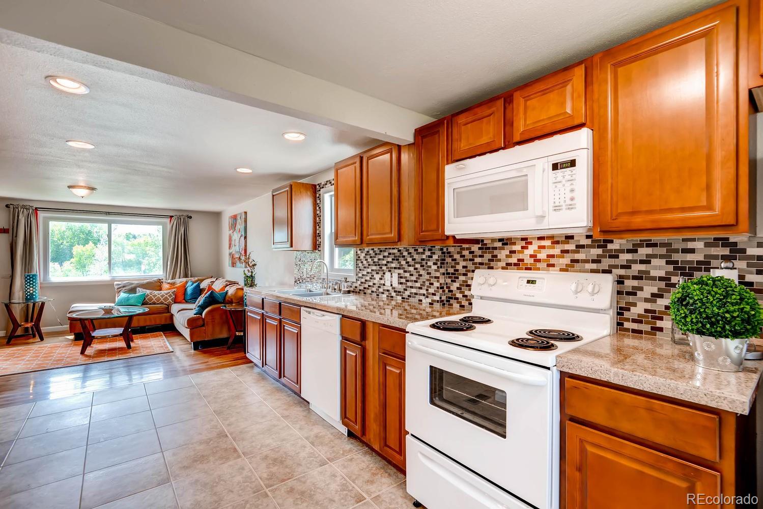 1760 South Java Way Denver, CO 80219 - Photo 10 of 28 a large kitchen with stainless steel appliances granite countertop a stove and a sink