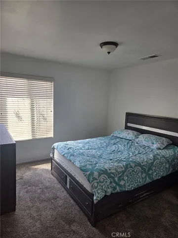 a bed sitting in a bedroom next to a window