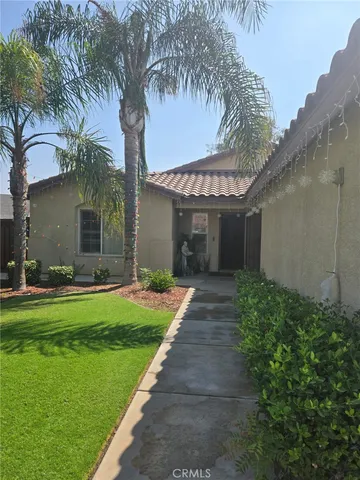 a front view of a house with a garden and yard