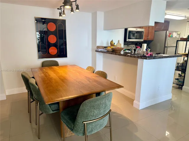 a view of a workspace with furniture and a refrigerator