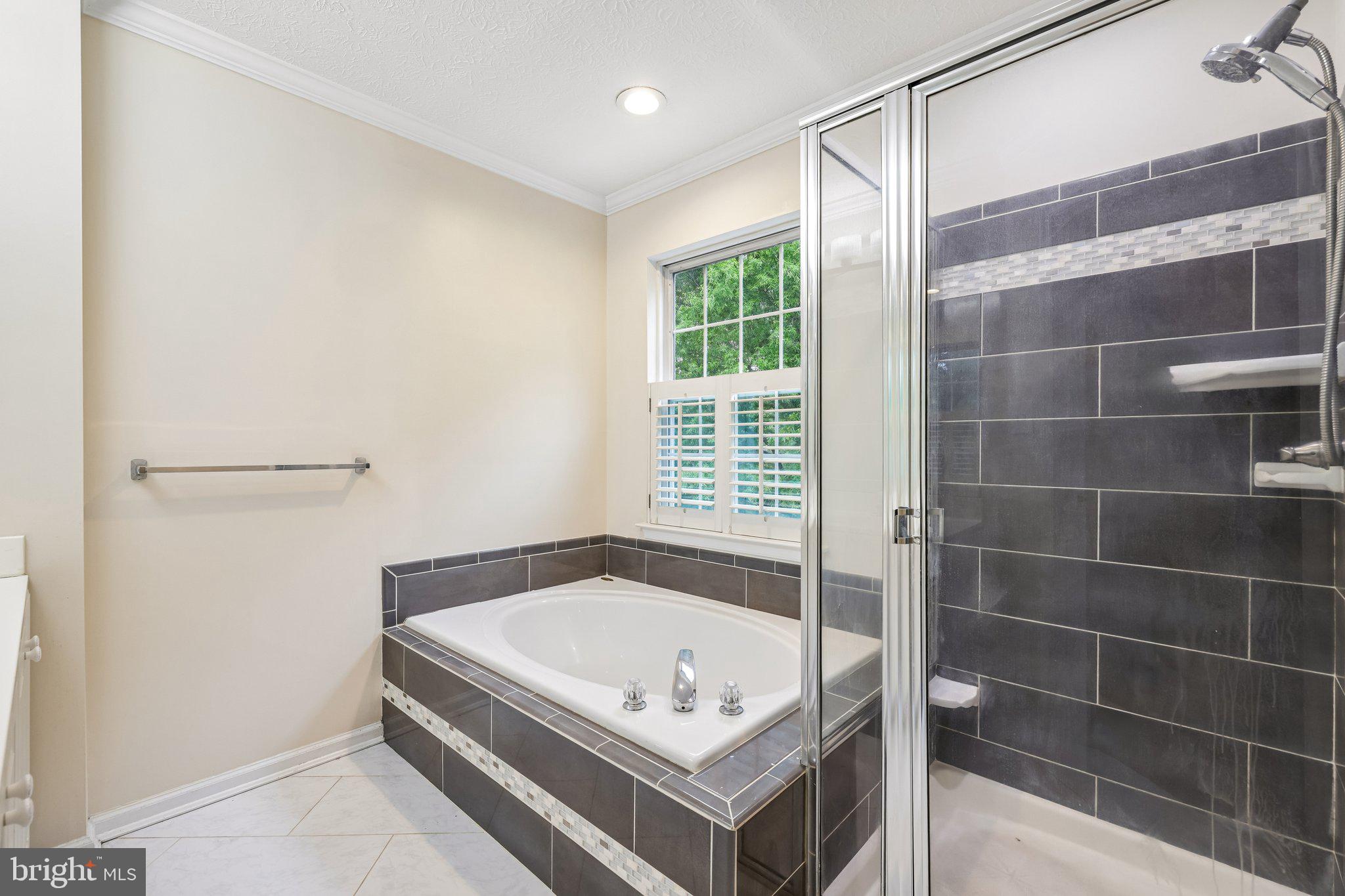 8727 Thornbrook Drive Odenton, MD 21113 - Photo 25 of 40 a bathroom with a tub and a shower