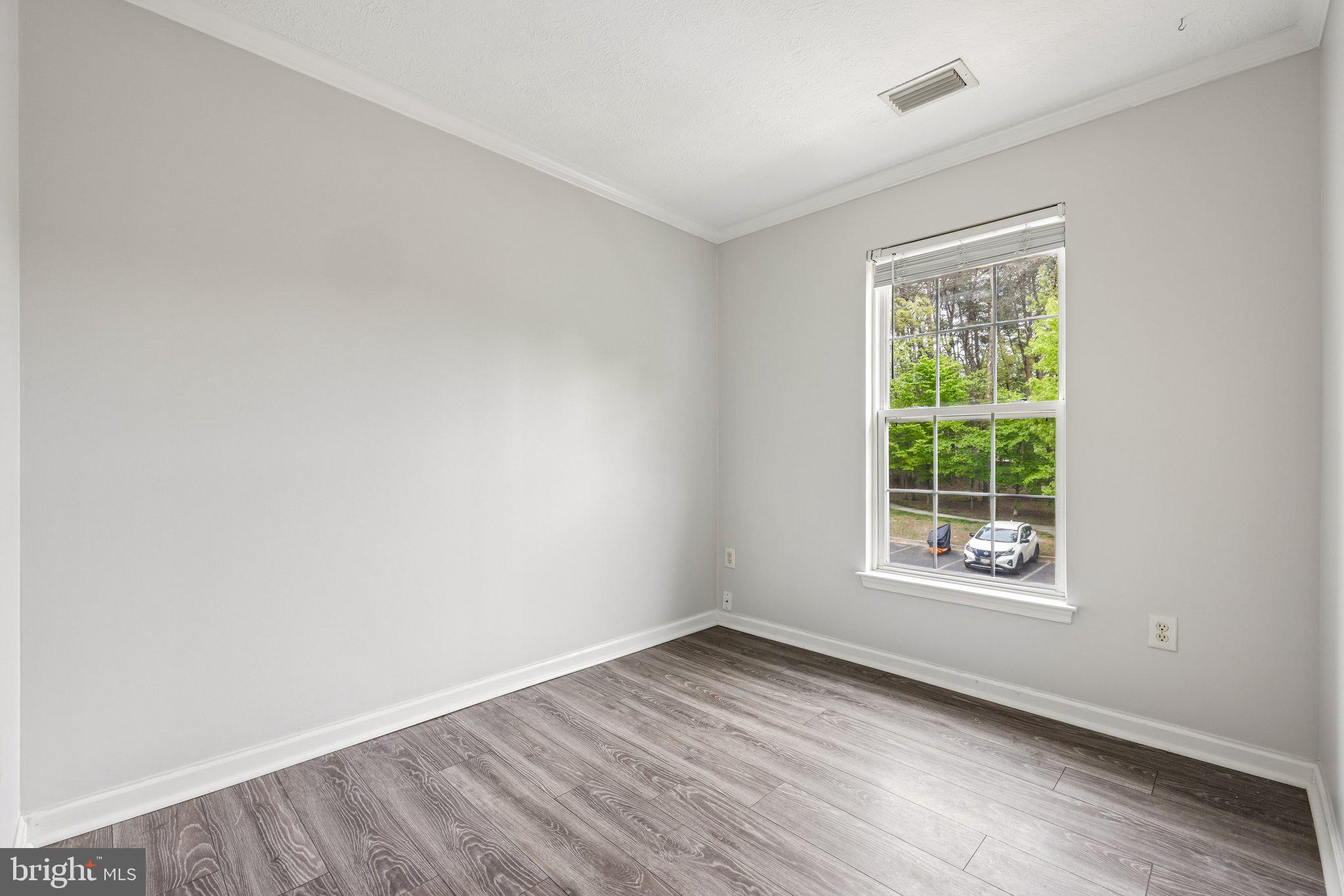 8727 Thornbrook Drive Odenton, MD 21113 - Photo 28 of 40 an empty room with wooden floor and windows