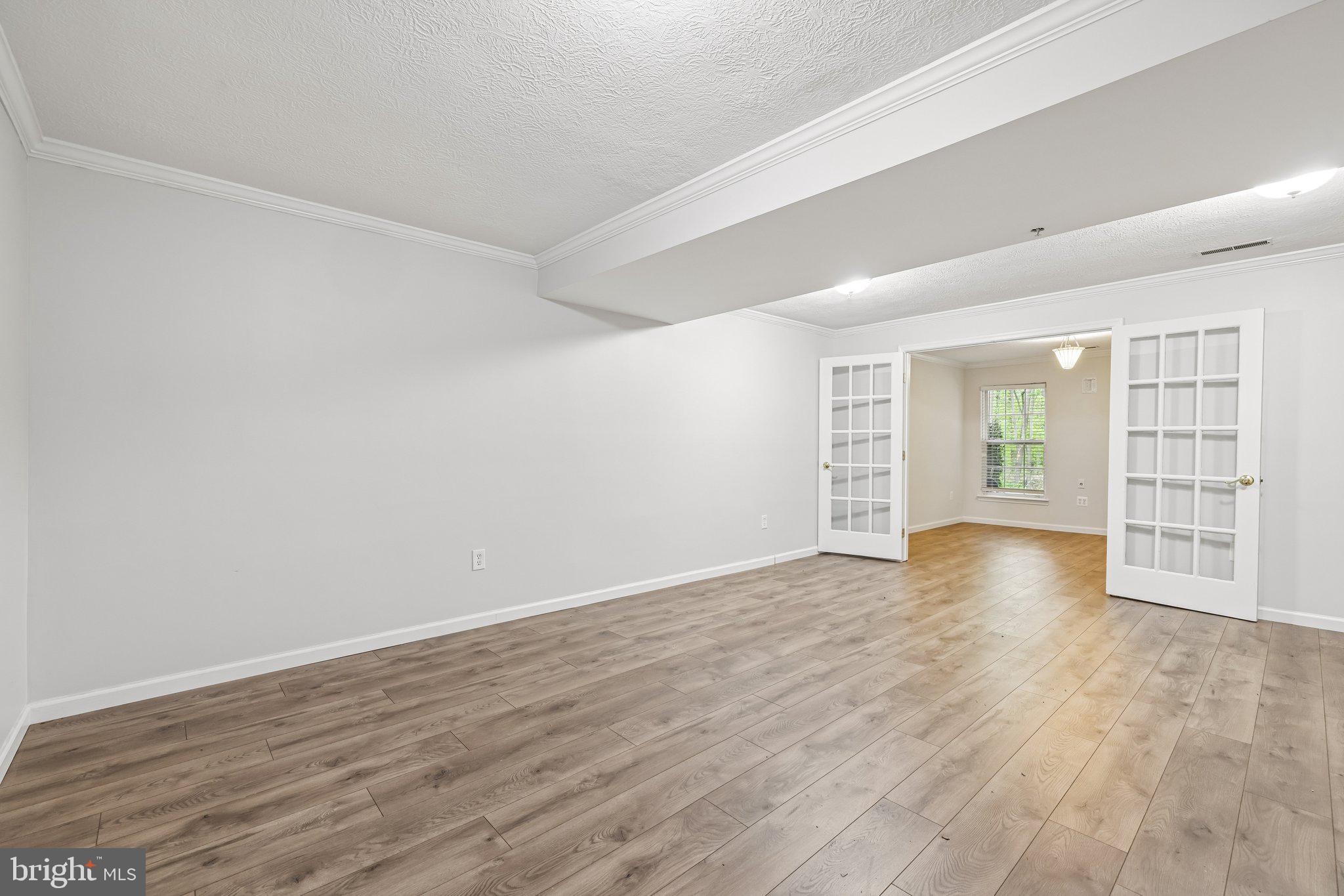 8727 Thornbrook Drive Odenton, MD 21113 - Photo 5 of 40 a view of an empty room with wooden floor and a window