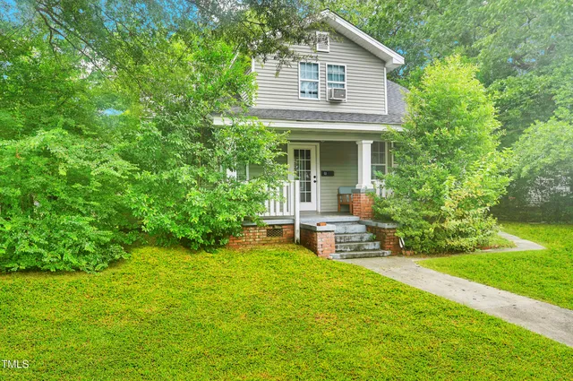 a view of a house with a yard and sitting area