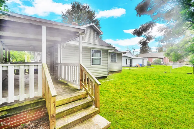 a view of a house with backyard and wooden fence
