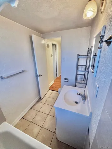 a bathroom with a tub sink and mirror