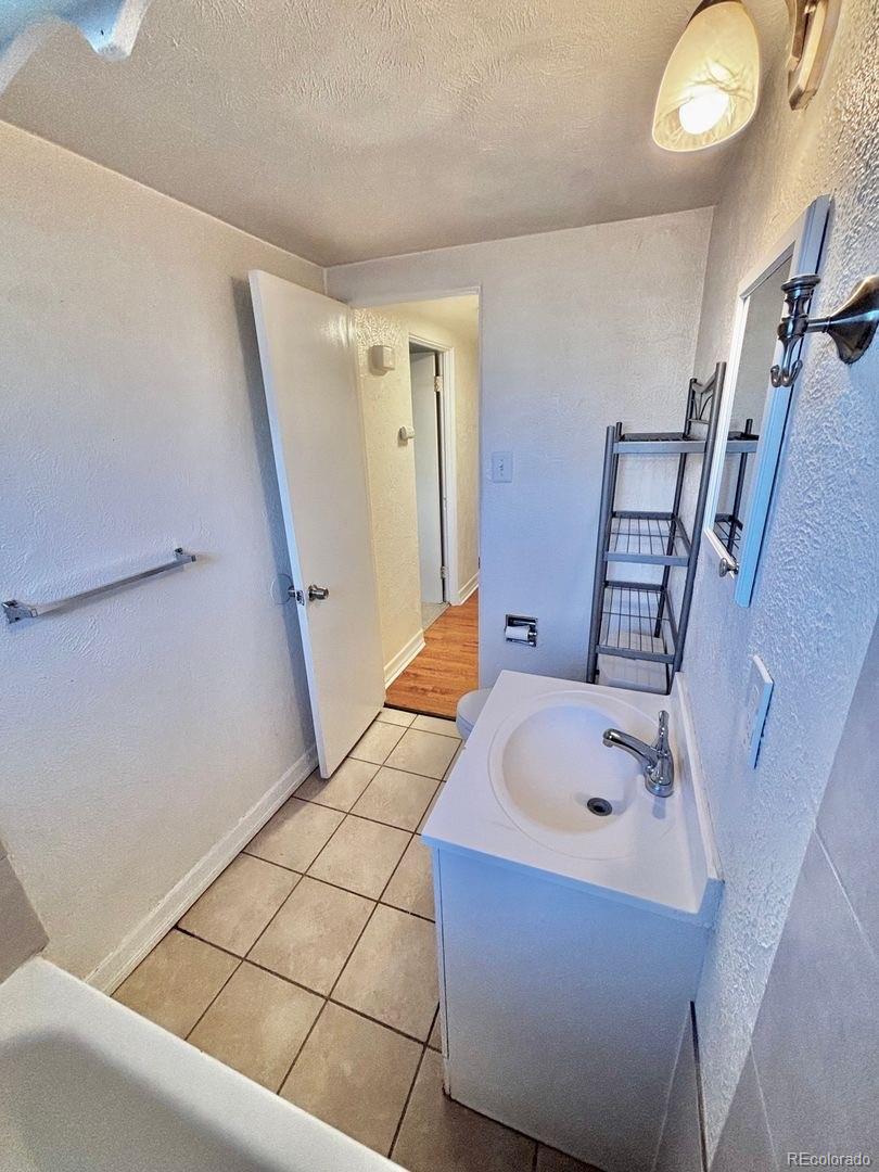 3475 Ames Street, Unit C Wheat Ridge, CO 80212 - Photo 14 of 17 a bathroom with a tub sink and mirror
