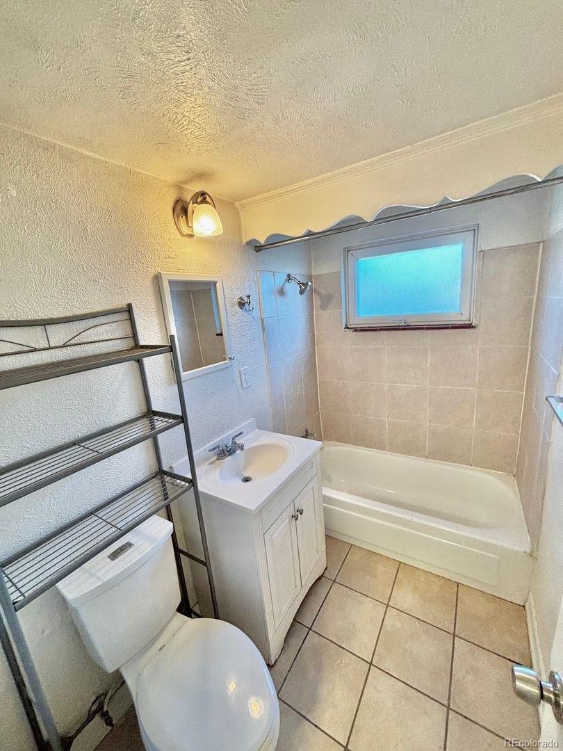 3475 Ames Street, Unit C Wheat Ridge, CO 80212 - Photo 15 of 17 a bathroom with a sink a toilet and shower