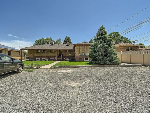 a view of a big house with a big yard and large trees
