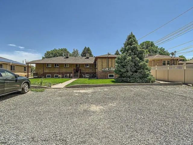 a view of a big house with a big yard and large trees