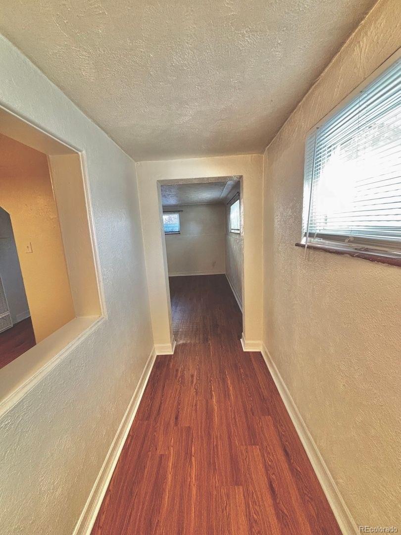 3475 Ames Street, Unit C Wheat Ridge, CO 80212 - Photo 3 of 17 a view of a room with wooden floor and brick walls