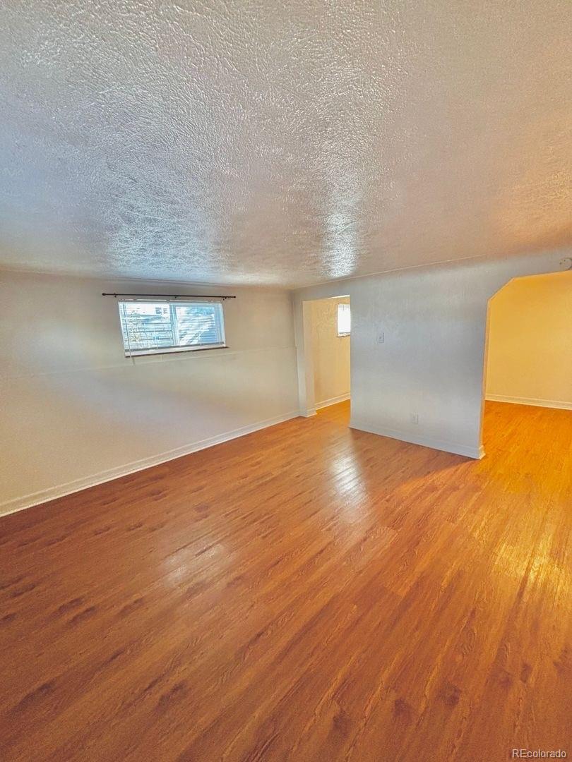 3475 Ames Street, Unit C Wheat Ridge, CO 80212 - Photo 5 of 17 an empty room with wooden floor and windows