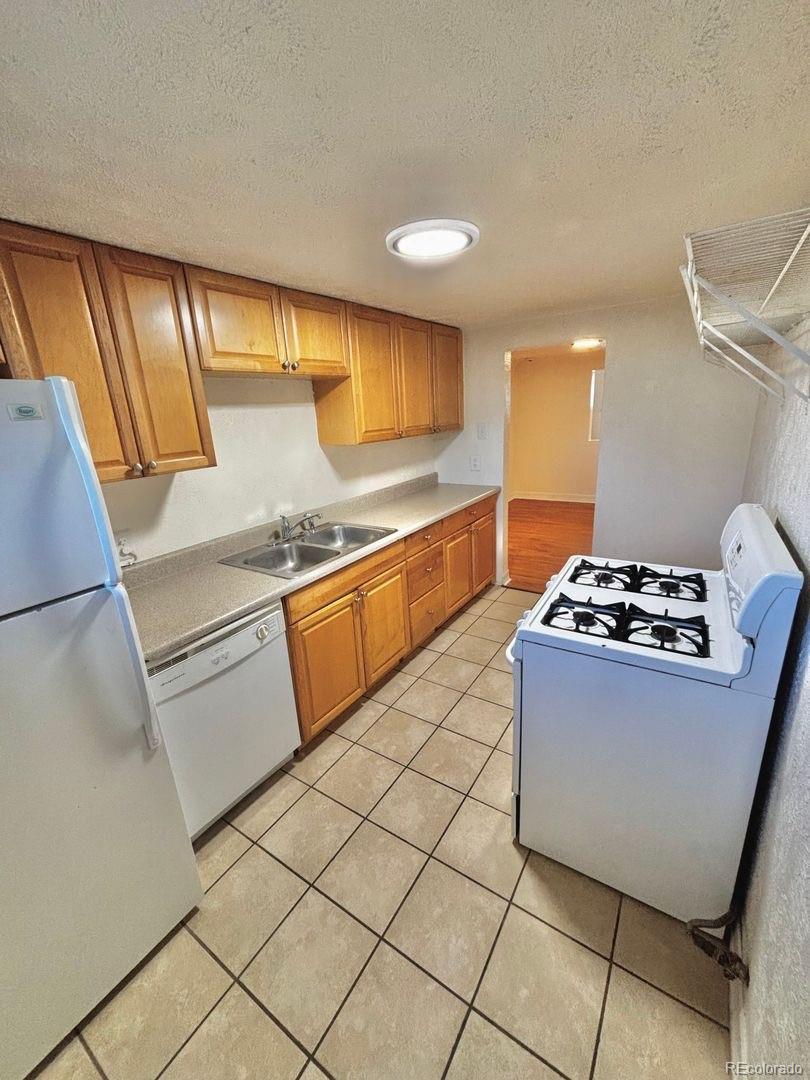 3475 Ames Street, Unit C Wheat Ridge, CO 80212 - Photo 9 of 17 a kitchen with stainless steel appliances granite countertop a sink stove and cabinets
