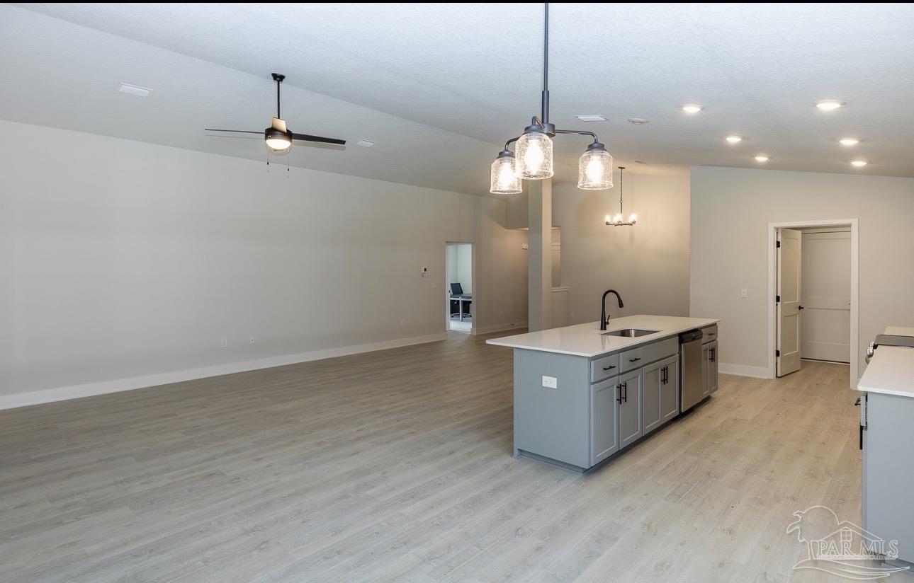 7657 Small Pnes Street Milton, FL 32583 - Photo 14 of 26 a large room with kitchen island a chandelier and wooden floor