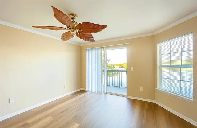 a view of an empty room with window and wooden floor
