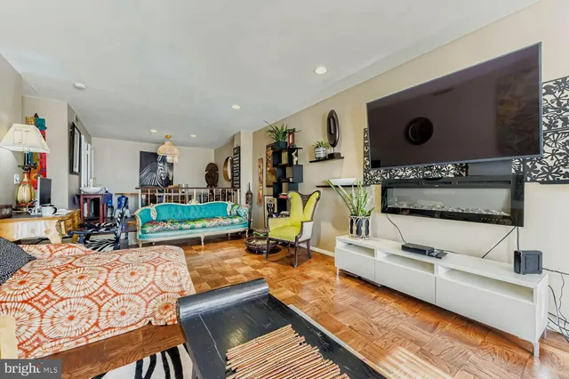 a living room with furniture a flat screen tv and a floor to ceiling window