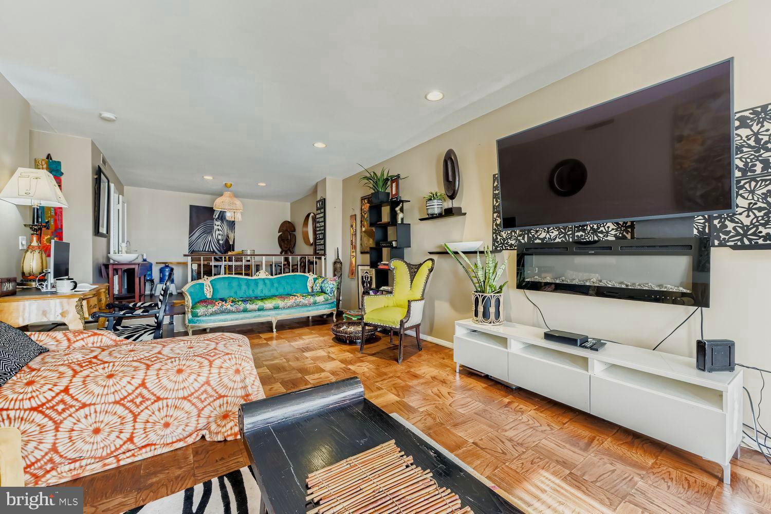 3601 Clarks Lane, Unit 508 Baltimore, MD 21215 - Photo 11 of 24 a living room with furniture a flat screen tv and a floor to ceiling window