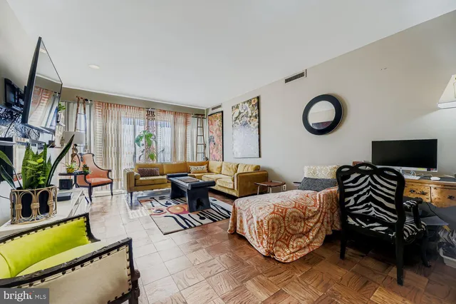 a living room with furniture a flat screen tv and a window