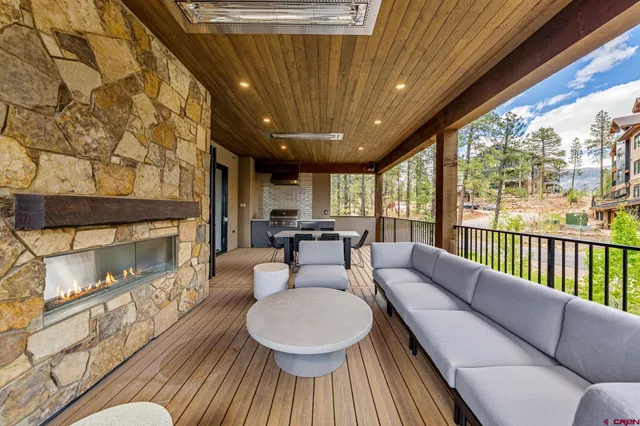 a living room with furniture a fireplace and a floor to ceiling window