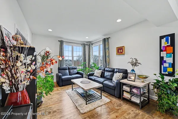 a living room with stainless steel appliances granite countertop furniture a rug a fireplace and a large window